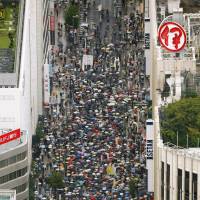 Thousands of people take part in a protest march in Shinjuku Ward, Tokyo, on Sunday against the government\'s security bills that would allow Japan to exercise the right to collective self-defense. | KYODO
