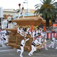 A group of men pull a huge wooden float at high speed through the streets in the city of Kishiwada, Osaka Prefecture, during the Kishiwada Danjiri Festival on Saturday. A total of 34 floats, each weighing 4 tons, were paraded through the streets for the annual two-day spectacle, which began the same day. | KYODO