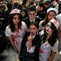 Nursing wounds: Halloween revelry peaked Saturday night in Japan and the area around Shibuya Station, in particular, saw a massive convergence of people decked out in a variety of costumes. | YOSHIAKI MIURA