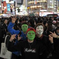 Masked identities: Halloween revelry peaked Saturday night in Japan and the area around Shibuya Station, in particular, saw a massive convergence of people decked out in a variety of costumes. | YOSHIAKI MIURA