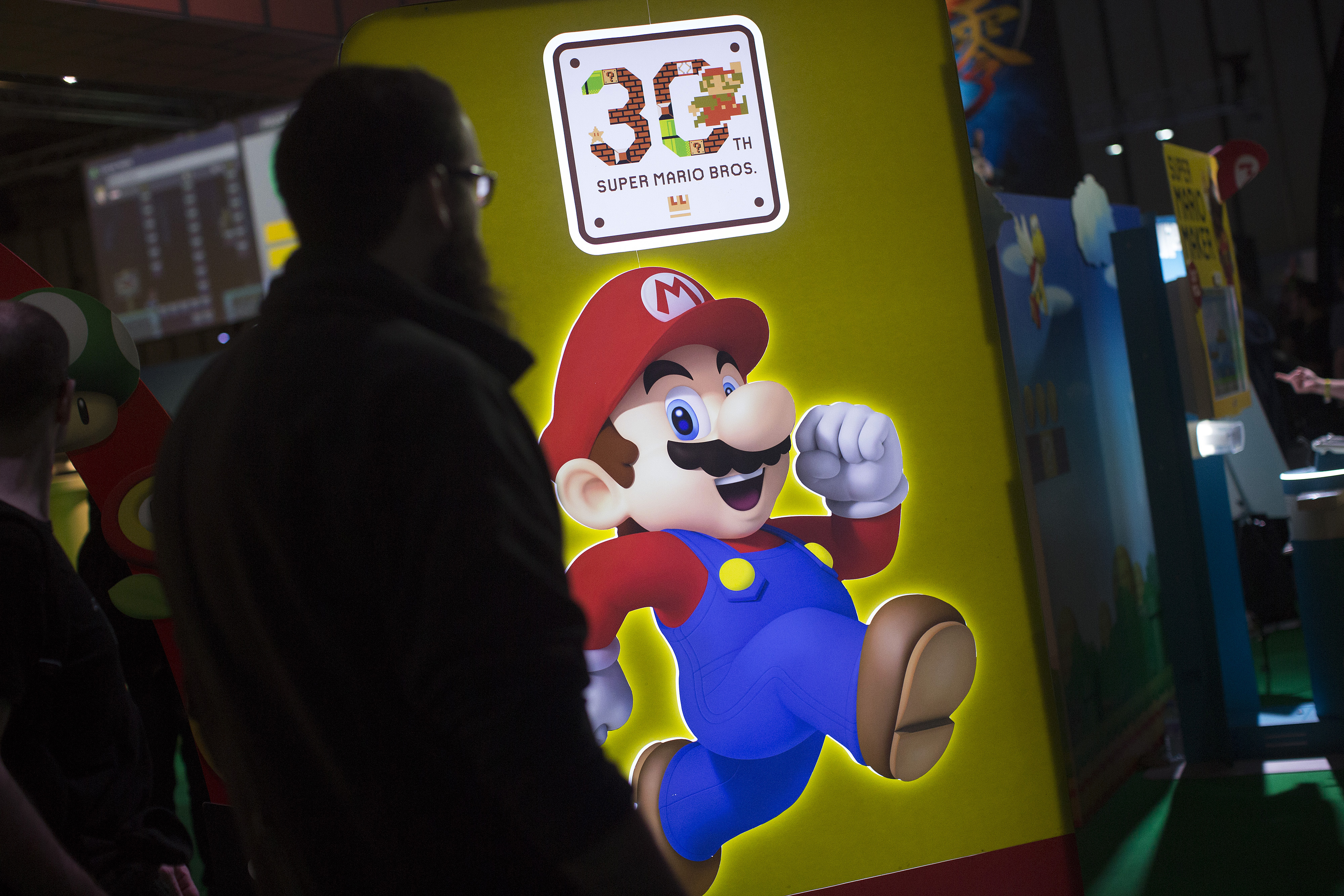A visitor walks past a Super Mario logo at a Nintendo Co. stand at the EGX 2015 video game conference in Birmingham, England, in September. Nintendo has been dropped for the first time from U.S.-based Interbrand's list of the top 100 global brands. | BLOOMBERG