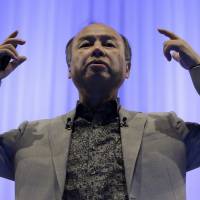 Masayoshi Son, chairman and chief executive officer of SoftBank Group Corp., gestures as he speaks during a SoftBank Academia lecture in Tokyo on Thursday. | BLOOMBERG
