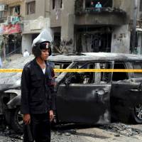 Police investigate a car-bomb attack on the convoy of public prosecutor Hisham Barakat near his house in the Heliopolis district of Cairo on June 29. Former special forces officer Hisham al-Ashmawy is blamed for the bombing and other high-profile attacks in Egypt. | REUTERS