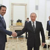 Russian President Vladimir Putin shakes hands with Syrian President Bashar Assad during a meeting at the Kremlin in Moscow on Tuesday. Assad made a surprise visit to Moscow on Tuesday evening to thank Putin for launching airstrikes against Islamist militants in Syria. | REUTERS