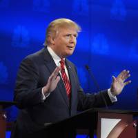 Donald Trump speaks as Ben Carson looks on during the CNBC Republican presidential debate at the University of Colorado, Wednesday. | AP