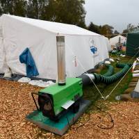 A heater warms tents at a refugee camp in Celle, Germany, on Thursday. With the approach of winter, authorities are scrambling to find warm places to stay for the thousands of refugees streaming into Germany every day. | REUTERS