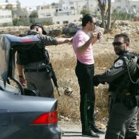 Israeli border police search a man driving out of the Palestinian neighborhood of Jabal Mukaber in Jerusalem Wednesday. Israel erected checkpoints and deployed several hundred soldiers in the Palestinian areas of the city Wednesday as it stepped up security following a series of attacks in Jerusalem. | AP