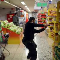 An Israeli policeman searches a supermarket inside the Central Jerusalem Bus Station after police said a woman was stabbed by a Palestinian outside the bus station Wednesday. | NOAM MOSKOWITZ / REUTERS