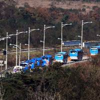 A convoy of buses carrying dozens of South Koreans crosses the border Saturday at Goseong, in South Korea. The passengers were being taken to North Korea’s Diamond Mountain resort to attend family reunions organized by the two nations. Hundreds of South Koreans cross border into North Korea to attend family reunions