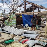 A resident stands in front of a house destroyed by Typhoon Koppu in Casiguran town, northeast of Manila, on Wednesday.  | AFP-JIJI