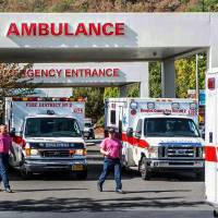 Paramedics return to their ambulances after delivering patients to Mercy Medical Center in Roseburg, Oregon, following a deadly shooting at Umpqua Community College Thursday. | AARON YOST / ROSEBURG NEWS-REVIEW VIA AP