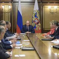 Russian President Vladimir Putin (center) chairs a meeting with members of the Security Council in Sochi on Saturday. | REUTERS