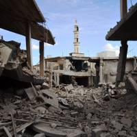 Buildings and a minaret in the central Syrian town of Talbisseh lie damaged Wednesday after Russian warplanes carried out airstrikes in three Syrian provinces. AFP-JIJI | AFP-JIJI