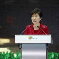 South Korean President Park Geun-hye speaks next to the Presidents Cup trophy during the opening ceremony for the 2015 Presidents Cup golf tournament in Incheon on Oct. 7. Park\'s government announced plans Monday to adopt new government-backed history textbooks for middle and high schools. | REUTERS