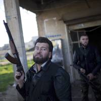 Free Syrian Army fighters look at a Syrian Army jet in Fafeen village, north of Aleppo province, in December 2012. | AP