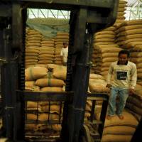 Workers are seen at a rice mill in Udon Thani, Thailand, on Sept. 16. The removal of generous agricultural subsidies has left rice farmers in northeast Thailand struggling with mounting debts, and they will get little relief when they sell their crop in coming months with rice prices near an 8-year low. | REUTERS