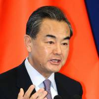 Chinese Foreign Minister Wang Yi gives a lecture at a symposium in Beijing on Tuesday, ahead of a trilateral summit involving Japan and South Korea. | KYODO
