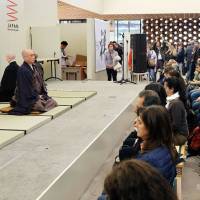 Led by Buddhist monks, visitors to the Japan Pavilion at the world exposition in Milan try out zazen, or seated meditation. | KYODO