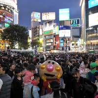 A large crowd of Halloween revelers mill about in Hachiko Square in front of JR Shibuya Station in Tokyo on Saturday night. | YOSHIAKI MIURA