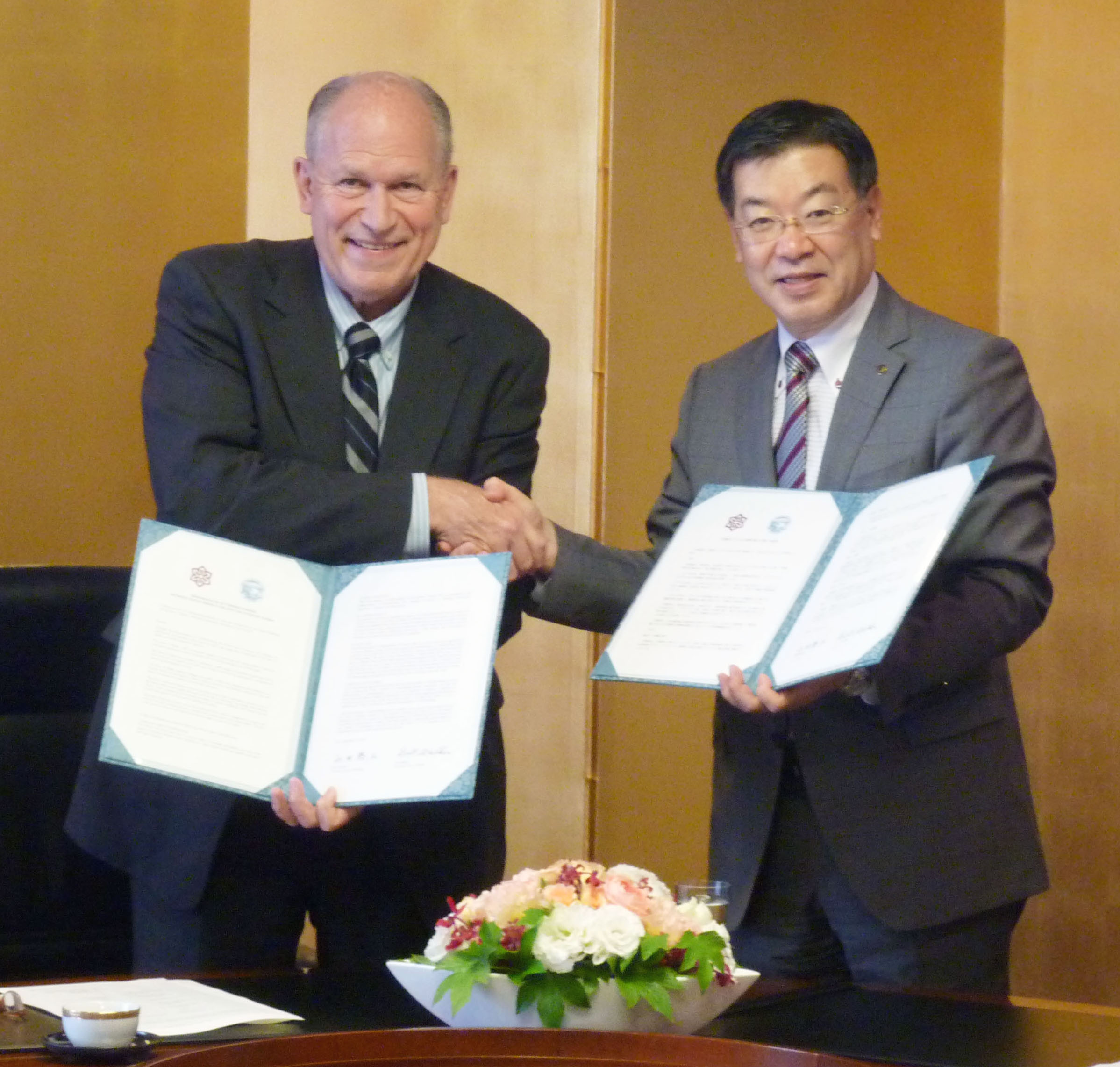 Kyoto Gov. Keiji Yamada (right) shakes hands with Alaska Gov. Bill Walker after signing an agreement Sept. 15 in Tokyo to look into ways to import Alaskan LNG to Maizuru. | KYODO
