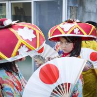 A girl looks up as she attends the Honensai festival to pray for a good harvest in Nago. | ARI HATSUZAWA
