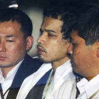 Murder suspect Vayron Jonathan Nakada Ludena is escorted by officers into the Kumagaya Police Station in Saitama Prefecture after his arrest on Oct. 8. | KYODO
