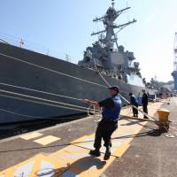 Port workers heave lines as the USS Benfold arrives Monday at Yokosuka, Kanagawa Prefecture. The U.S. Navy said the destroyer carries the most advanced ship-borne ballistic missile tracking and interception system available. | ALASTAIR WANKLYN