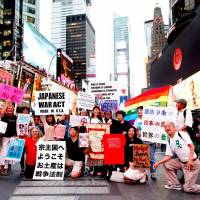 We\'re walkin\' here: OVERSEAs activists pose during the \"#ImNotAbe We Love Article 9\" action in Times Square, New York, on Sept. 29. | MASATO KURODA