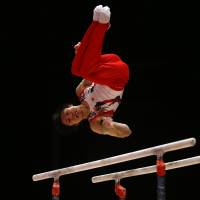 Kohei Uchimura performs on the parallel bars at the World Artistic Gymnastics Championships on Sunday in Glasgow, Scotland. | AP