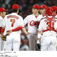 The Carp meet on the mound during the sixth inning on Wednesday in Hiroshima. | KYODO