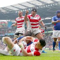 Japan\'s Kensuke Hatakeyama (center) celebrates a try scored by Akihito Yamada during the Brave Blossoms\' 26-5 victory over Samoa at the Rugby World Cup on Saturday in Milton Keynes, England. | GETTY / KYODO