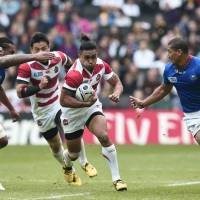 Japan\'s Male Sa\'u bursts between two Samoa defenders during their Rugby World Cup match in Milton Keynes, England, on Sunday. | AFP-JIJI
