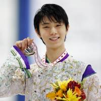 Yuzuru Hanyu holds up his medal after winning the Autumn Classic International in Barrie, Ontario, on Thursday night. Hanyu won with a total score of 277.19. | KYODO