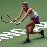 Petra Kvitova hits a return to Garbine Muguruza during their Friday round-robin match at the WTA Finals in Singapore. Muguruza defeated Kvitova 6-4, 4-6, 7-5. | AFP-JIJI