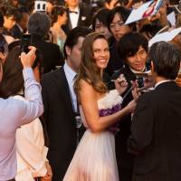 Hilary Swank pauses to sign autographs and to pose for photos during her red carpet stroll at the opening of the 2015 Tokyo International Film Festival.  | MANCE THOMPSON