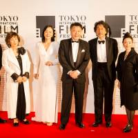 Masato Harada (fourth from left), director of \"The Emperor in August,\" and leading actor Koji Yakusho (third from right), pose with cast members prior to the opening of the 2015 Tokyo International Film Festival. | MANCE THOMPSON