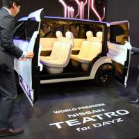 Staff open the doors of the Nissan Teatro for Dayz at the 44th Tokyo Motor Show 2015, which continues until Nov. 8. | SATOKO KAWASAKI