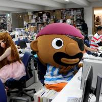 Employees dressed as Licca-chan doll and Pop-up Pirate as they work at their desks. | AFP-JIJI