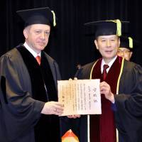 Turkish President Recep Tayyip Erdogan (left) receives an honorary doctorate from Waseda University President Kaoru Kamata during a conferral ceremony at the university\'s Masaru Ibuka Auditorium in Tokyo on Oct. 8. | YOSHIAKI MIURA