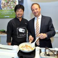 Wim de Veirman (right), CEO of The Cookware Company and GreenPan Japan, and Belgian Brasserie Court Antwerp Central chef Keita Yamahara demonstrate cooking with the healthy ceramic non-stick GreenPan during a press conference at the Belgian embassy in Tokyo on Oct. 23. | YOSHIAKI MIURA