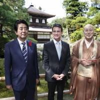 Prime Minister Shinzo Abe and French Prime Minister Manuel Valls (center) pose with Ginkakuji chief priest Raitei Arima during a visit to Ginkakuji Temple, commonly referred to as the \"Silver Pavilion\", in Kyoto on Sunday. | KYODO