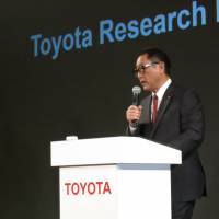 Toyota President Akio Toyoda speaks to the media in Tokyo on Friday. With him is Gill Pratt, who will serve as CEO at the Toyota Research Institute in California. | KAZUAKI NAGATA