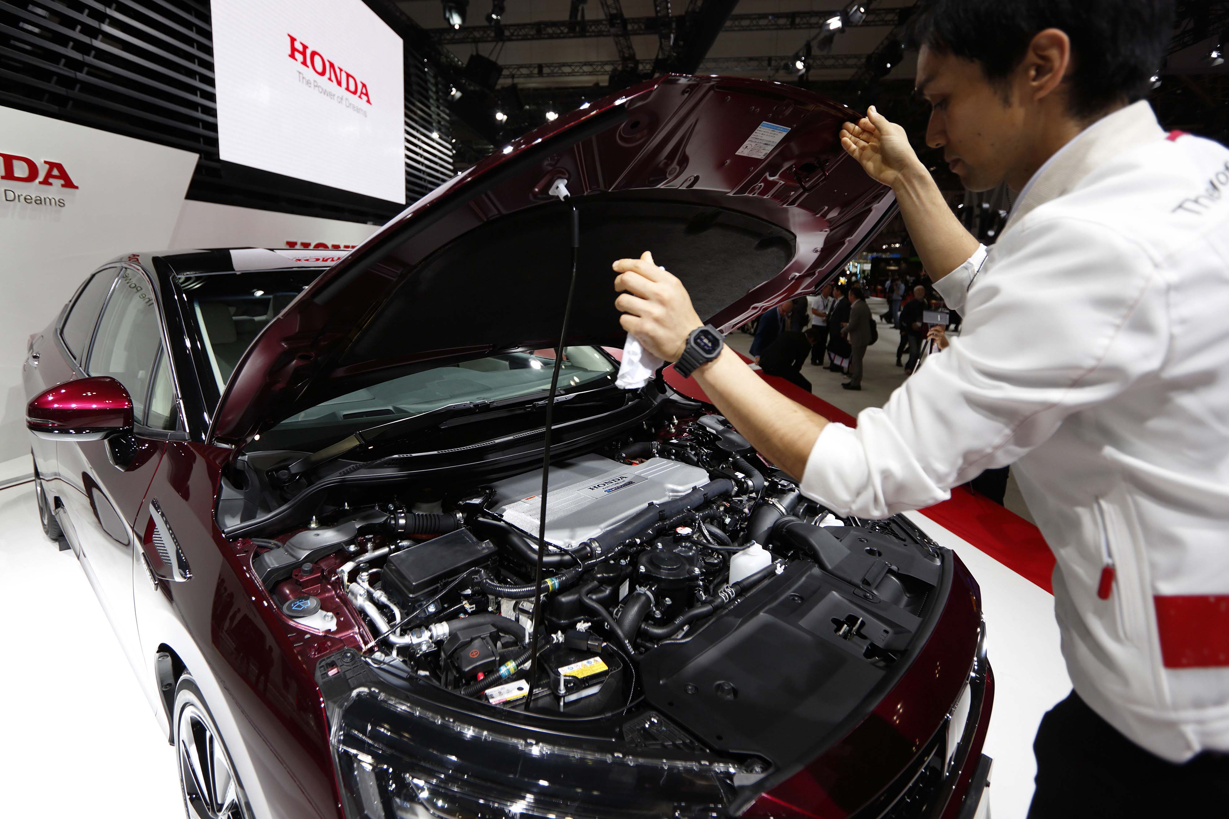 An attendant opens the hood of a Honda Motor Co. FCX Clarity fuel cell vehicle to show the hydrogen tank fitted inside, at the Tokyo Motor Show in October. | BLOOMBERG