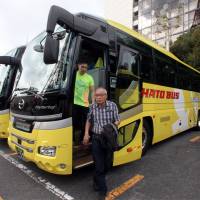 Tourists step off a coach during a sightseeing tour operated by Hato Bus Co. in Tokyo on Nov. 5. | BLOOMBERG