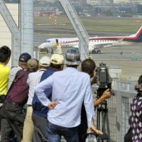 Aircraft enthusiasts gaze at a Mitsubishi Regional Jet from the observation deck at Nagoya Airport in October. | KYODO