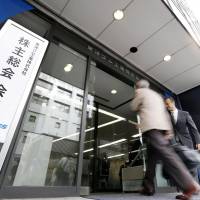 A shareholder enters the Toyo Tire &amp; Rubber Co. headquarters in Osaka on Thursday. | KYODO