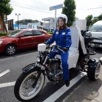 Toto demonstrates the Toilet Bike Neo, which uses biogas, in the city of Saitama, Saitama Prefecture, in August 2012. | AFP-JIJI