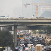 Traffic clogs a road on a polluted day in Beijing. China has been underreporting its coal consumption for years, experts said on Nov. 4, after reports that official statistics have been revised upwards by hundreds of millions of tons a year. The new figures suggest that Chinese emissions have been a significantly larger driver of global warming than previously thought. | AFP-JIJI