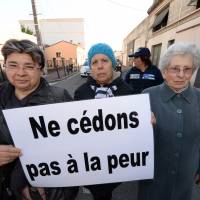 Women hold a placard which says \"Let\'s not give in to fear\" at a demonstration in Cenon, France, on Saturday. The event was a tribute to the victims of the Nov. 13 attacks in Paris. | AFP-JIJI