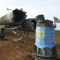 The Crimean Tatars flag covers a part of the damaged transmission tower close to the village of Chaplinka, Ukraine, on the Crimean border Sunday. | AP